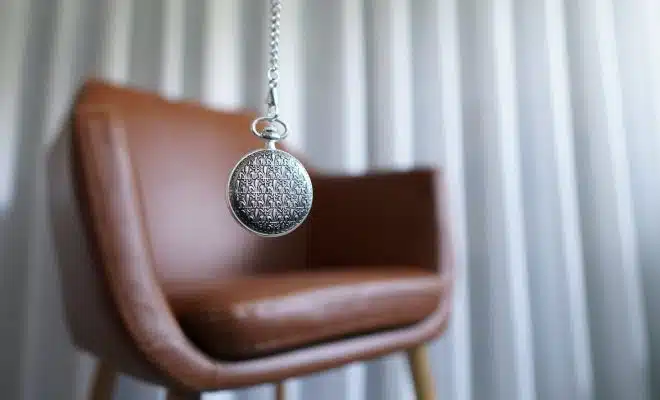 silver round pendant on brown wooden chair