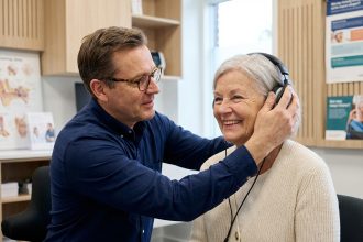 Audiologiste aidant une senior en clinique d'audition
