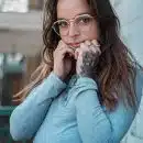 woman in blue sweater wearing eyeglasses