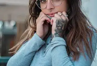 woman in blue sweater wearing eyeglasses