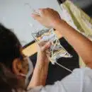 woman in white shirt holding clear plastic cup