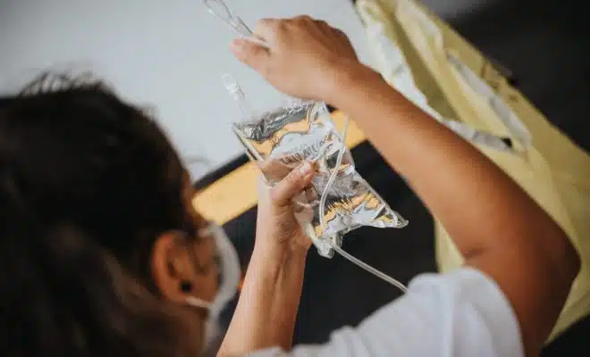 woman in white shirt holding clear plastic cup